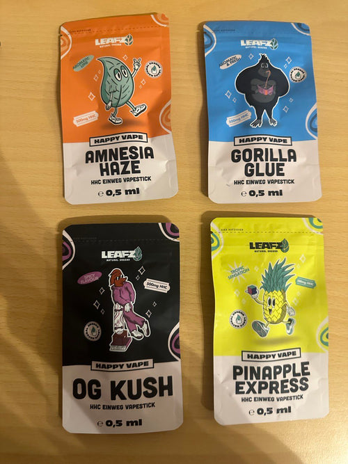 Leafz.de HCC Vapes Tüten in verschiedenen Geschmacksrichtungen. Eine orange-weiße Tüte für Amnesia Haze, eine blau-weiße Tüte für Gorilla Glue, eine schwarz-weiße Tüte für OG KUSH und eine gelb-weiße Tüte für Pinapple Express