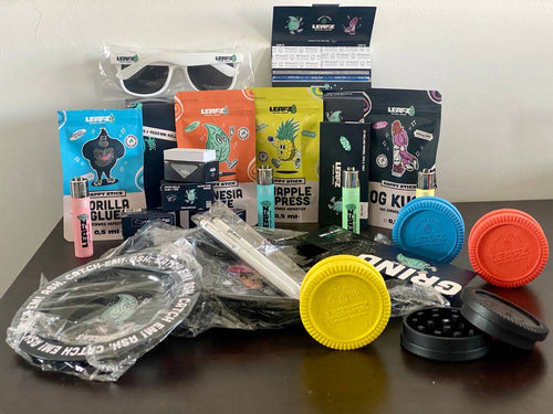Ein Tisch auf welchem diverse Produkte von Leafz.de liegen.Diverse Feuerzeuge in verschiedenen Farben sowie diverse Geschmacksrichtungen der HHC Vapes: Gorilla Glue, Pinapple Express, OG KUSH und Amnseis Haze
